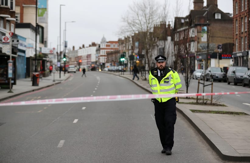 A police officer is seen near a site where a man was shot by armed officers in Streatham, south London, Britain, February 2, 2020. (photo credit: ANTONIO BRONIC/ REUTERS)
