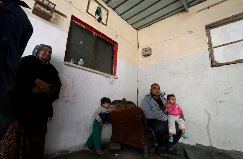 Palestinian man Eyad Al-Zahar carries his niece as he sits in his home in Gaza City January 19, 2020. Picture taken January 19, 2020 (photo credit: REUTERS/MOHAMMED SALEM)