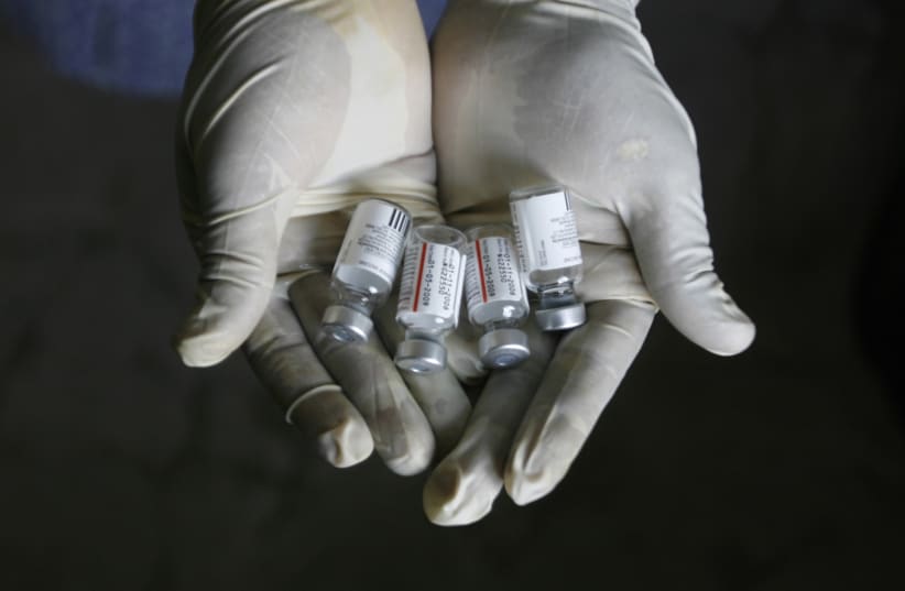 A health worker displays bottles of vaccine Pneumovax on the outskirts of Siliguri (photo credit: REUTERS)