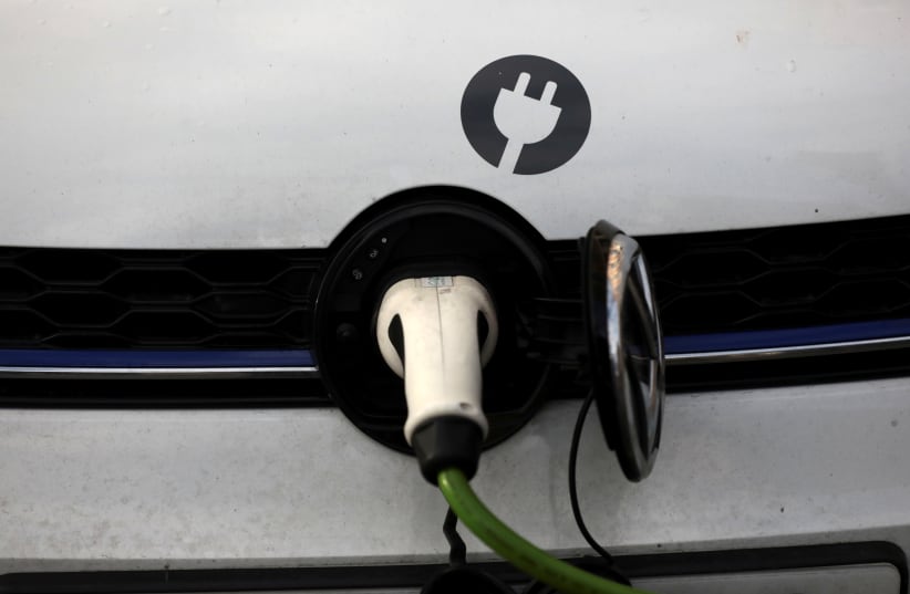 A car is plugged in at a charging point for electric vehicles in London (photo credit: REUTERS)