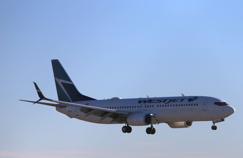 A WestJet Boeing 737-800 airplane lands at Vancouver's international airport in Richmond, British Columbia, Canada, February 5, 2019 (photo credit: REUTERS/BEN NELMS)