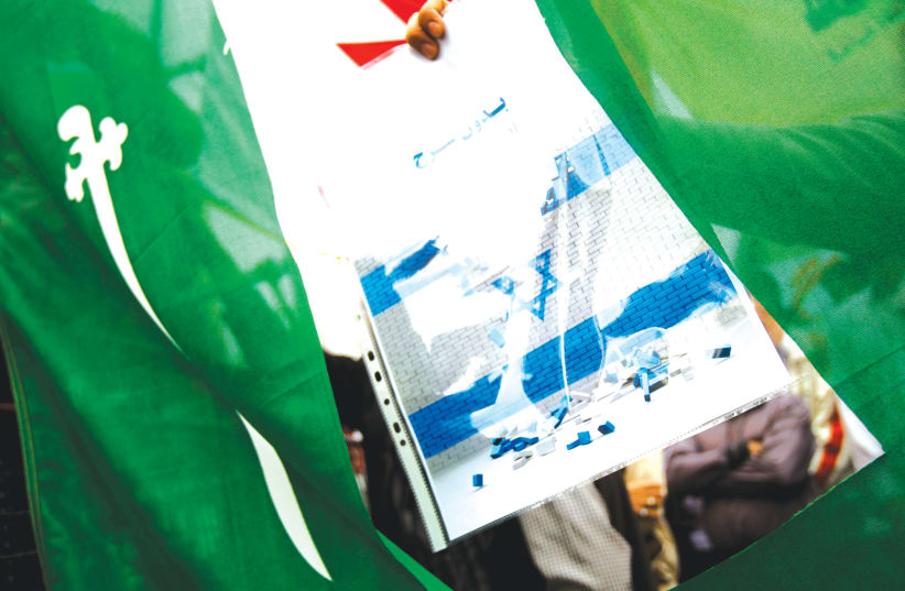 AN IRANIAN protester holds a poster with an Israeli flag. (photo credit: REUTERS)
