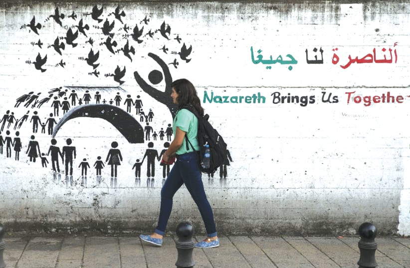 A young Arab woman walks on a street in Nazareth, one of the largest Arab municipalities in Israel.  (photo credit: REUTERS)