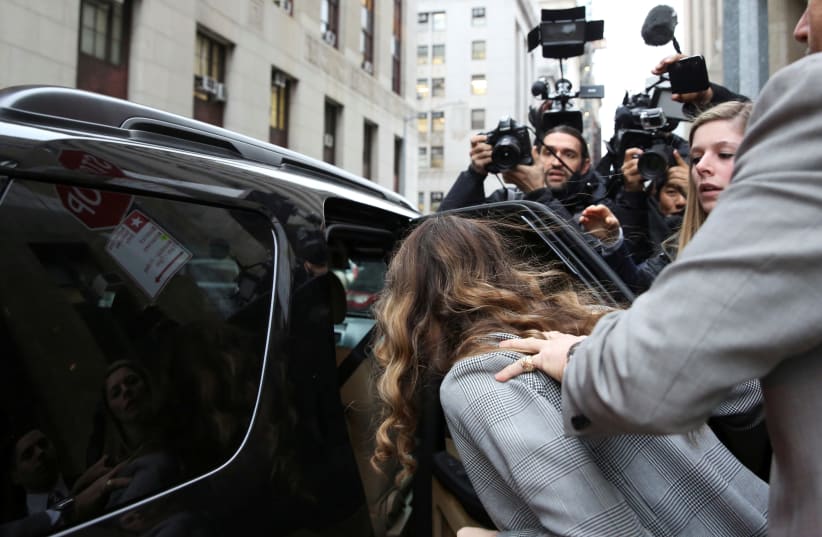 Witness Lauren Young hides her face from photographers as she departs the Criminal Court after testifying during the Harvey Weinstein sexual assault trial trial in the Manhattan borough of New York City (photo credit: REUTERS/CAITLIN OCHS)