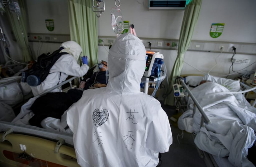 Medical workers in protective suits attend to novel coronavirus patients inside an isolated ward at a hospital in Wuhan, Hubei province, China February 6, 2020. Picture taken February 6, 2020 (photo credit: CHINA DAILY VIA REUTERS)