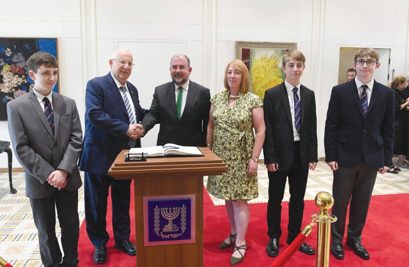 PRESIDENT REUVEN RIVLIN embraces Irish Ambassador to Israel Kyle O’Sullivan, accompanied by his wife and three sons, after O’Sullivan presented his credentials in 2019.  (photo credit: MARK NEYMAN/GPO)