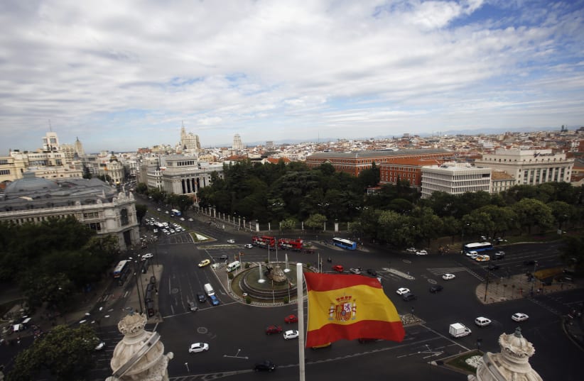 A Spanish flag flutters in the air as the capital of Spain is seen from the observatory deck of Madrid's city hall August 7, 2013.  (photo credit: REUTERS/SERGIO PEREZ)