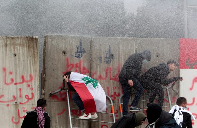 Demonstrators are sprayed with a water cannon during a protest seeking to prevent MPs and government officials from reaching the parliament for a vote of confidence, in Beirut, Lebanon February 11, 2020 (photo credit: REUTERS/AZIZ TAHER)