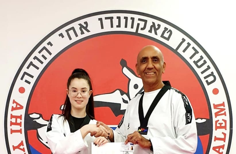 Encouraged by her coach Avi Kadouri, Amit receives her black belt (photo credit: RUBENS ZADEL)