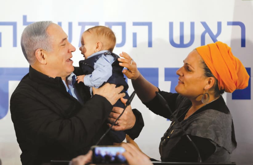 IT MUST be election season – Prime Minister Benjamin Netanyahu holds a baby during a campaign stop this week in Mevo’ot Yeriho. (photo credit: NIR ELIAS / REUTERS)