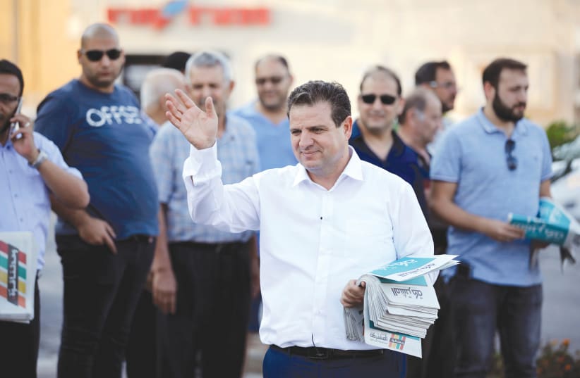 AYMAN ODEH, leader of the Joint List, gestures as he hands out pamphlets during an an election campaign event in Tira. (photo credit: REUTERS)