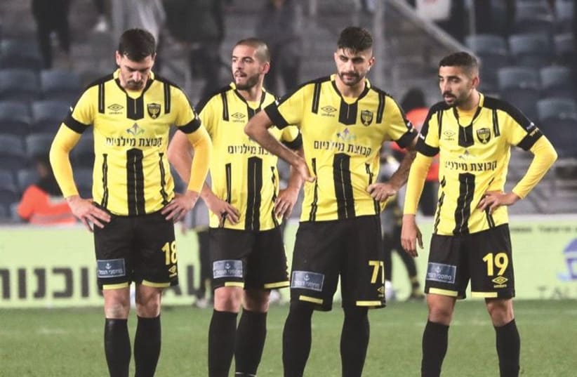 HAPOEL TEL AVIV celebrates after it earned a 1-0 victory in the capital on Monday night, while Beitar Jerusalem players (inset) wonder what went wrong.  (photo credit: DANY MAROM)