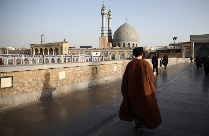 An Iranian cleric walks in front of the Shrine of Fatima Masumeh in Qom (photo credit: WANA NEWS AGENCY/REUTERS)
