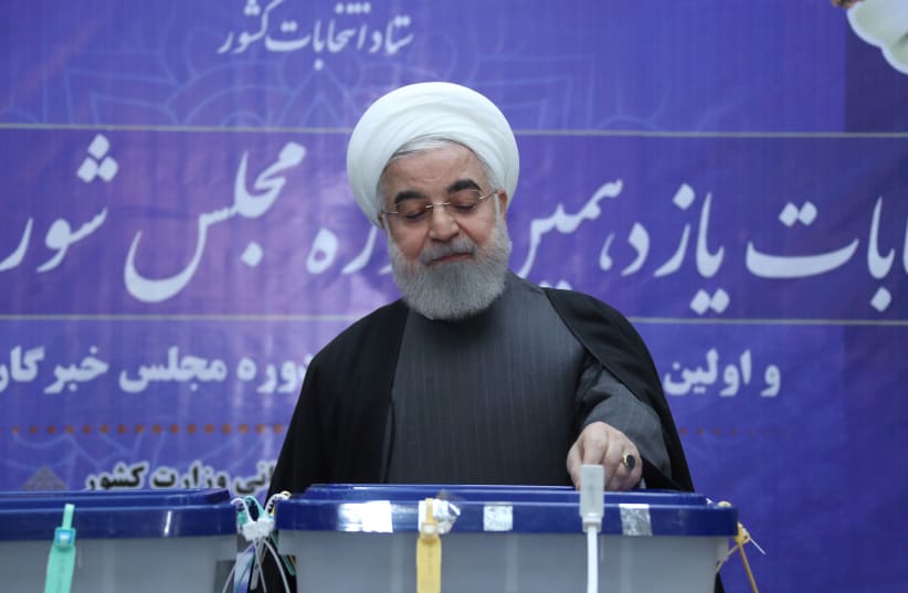 Iranian President Hassan Rouhani casts his vote at a polling station during parliamentary elections in Tehran, Iran February 21, 2020 (photo credit: REUTERS)