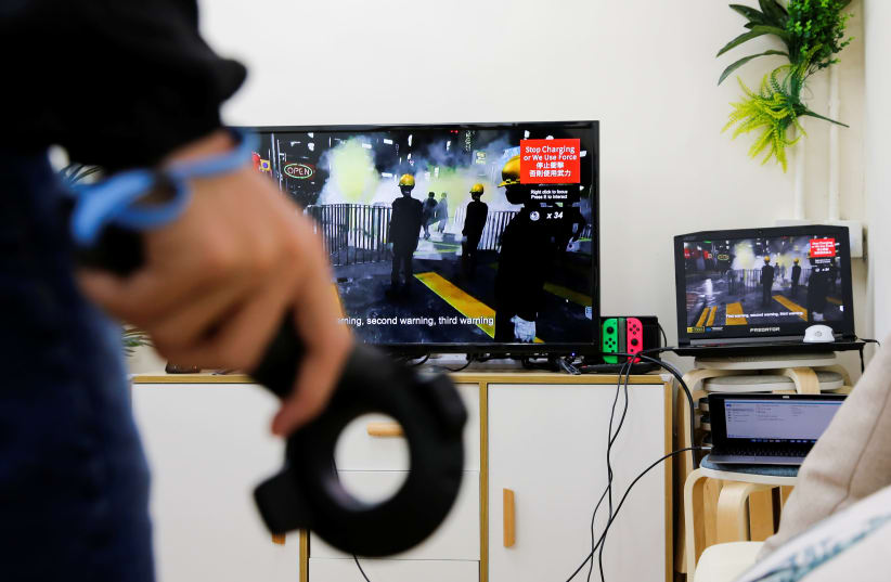 A member of a game developers team demonstrates a video game called "Liberate Hong Kong", that simulates the current anti-government protests, in Hong Kong (photo credit: REUTERS)