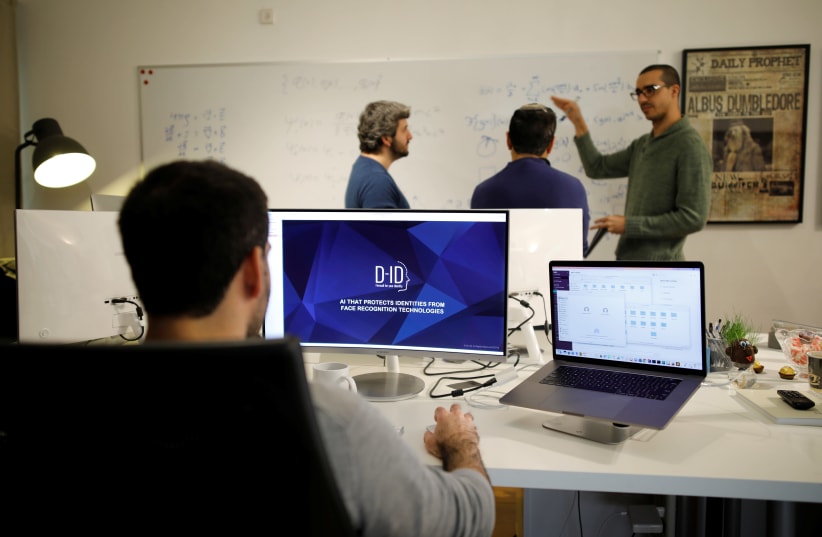 Employees of the D-ID startup company work at the company's office in Tel Aviv (photo credit: AMIR COHEN/REUTERS)