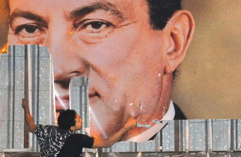 AN ANTI-GOVERNMENT protester defaces a picture of then-Egyptian president Hosni Mubarak in Alexandria, in 2011. (photo credit: REUTERS)