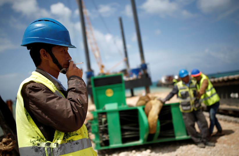 Chinese construction workers work during a media tour of the construction of a new port in the southern city of Ashdod, Israel April 12, 2016. The new port in Ashdod together with another one in Haifa are both under construction and are planned to start operating at the end of 2021. (photo credit: REUTERS)