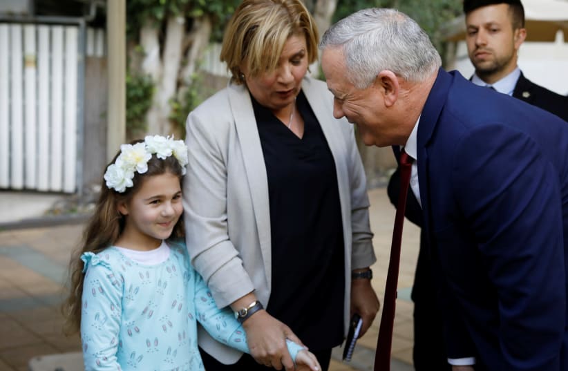Benny Gantz, head of Blue and White party, greets a child after giving a statement to the media in Ramat Gan, Israel March 1, 2020 (photo credit: NIR ELIAS / REUTERS)