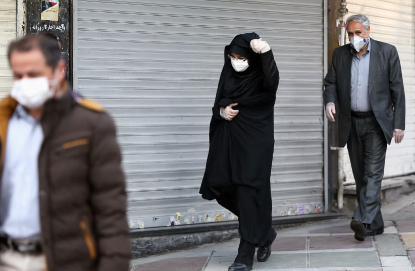 Iranian people wear protective masks to prevent contracting a coronavirus, in Tehran, Iran February 29, 2020 (photo credit: REUTERS)