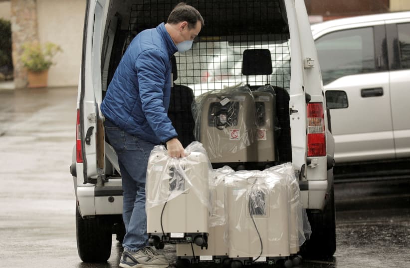A driver delivers oxygen therapy devices at the Life Care Center of Kirkland, the long-term care facility linked to several confirmed coronavirus cases in the state, in Kirkland, Washington, U.S. March 2, 2020. (photo credit: REUTERS/DAVID RYDER)