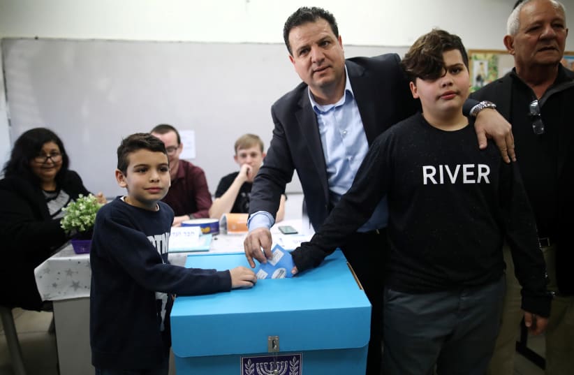 Leader of Joint List party, Ayman Odeh casts his ballot together with his sons at a polling station as Israelis vote in a national election in Haifa, Israel March 2, 2020 (photo credit: AMMAR AWAD/REUTERS)