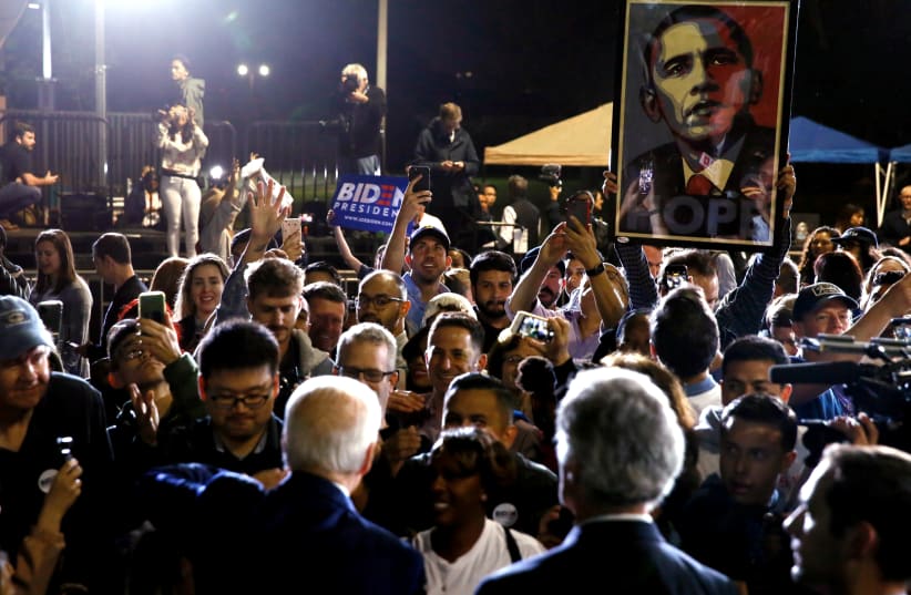 Supporters of Democratic U.S. presidential candidate and former Vice President Joe Biden hold up a HOPE poster of former President Barack Obama as he shakes hands with the crowd at his Super Tuesday night rally in Los Angeles, California, U.S., March 3, 2020 (photo credit: REUTERS/ELIZABETH FRANTZ)