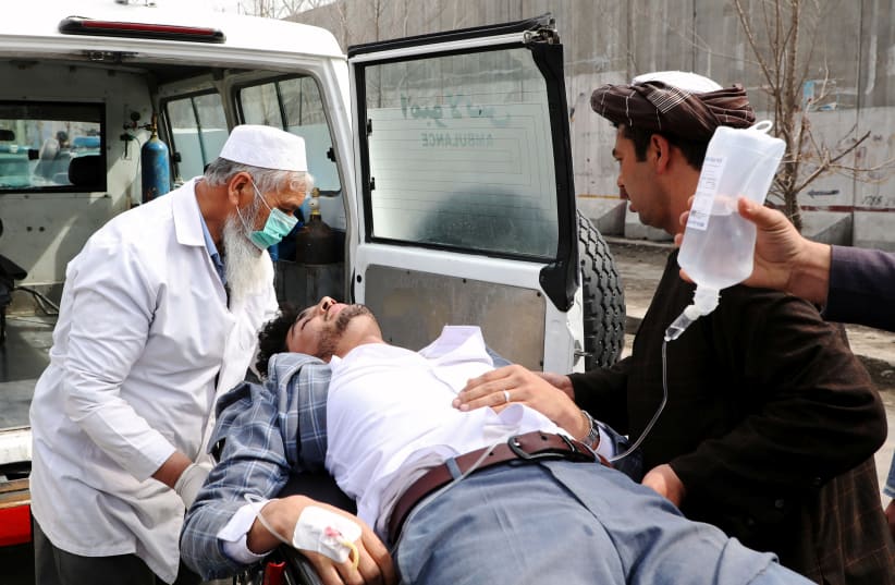 Hospital workers carry an injured person after an attack in Kabul, Afghanistan March 6, 2020. (photo credit: OMAR SOBHANI / REUTERS)