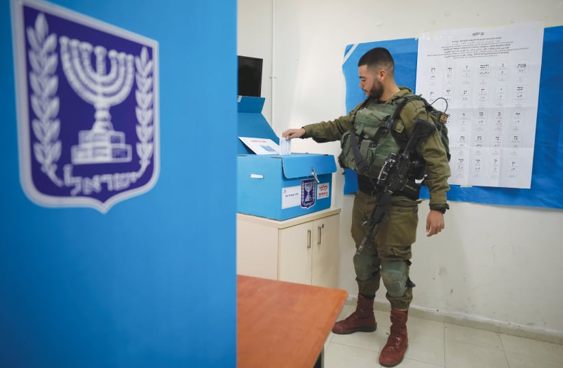 A SOLDIER casts his ballot on Monday at a mobile polling station near Kibbutz Zikim in the South.  (photo credit: AMIR COHEN/REUTERS)