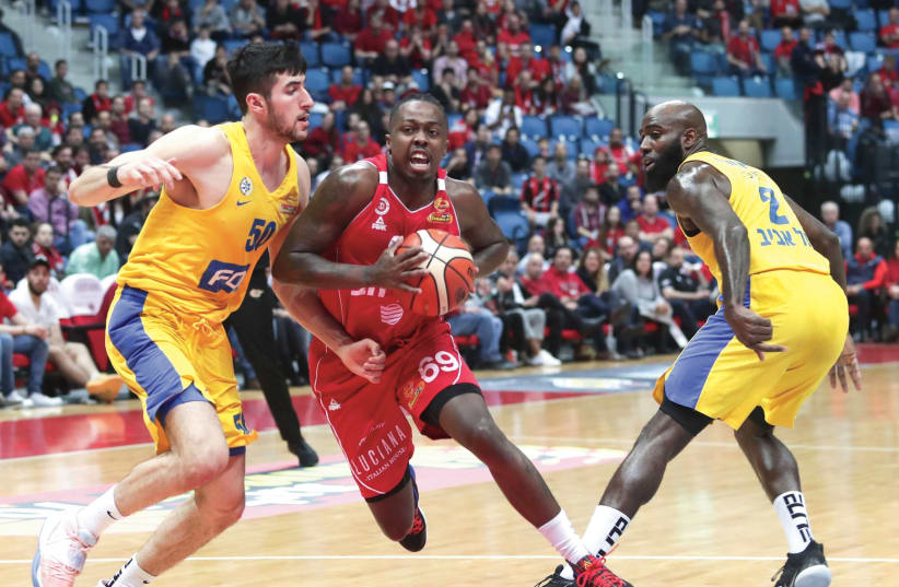 HAPOEL JERUSALEM guard J’Covan Brown splits the Maccabi Tel Aviv defense during the Reds’ 98-87 home victory over the yellow-and-blue. March 8 2020. (photo credit: DANNY MARON)