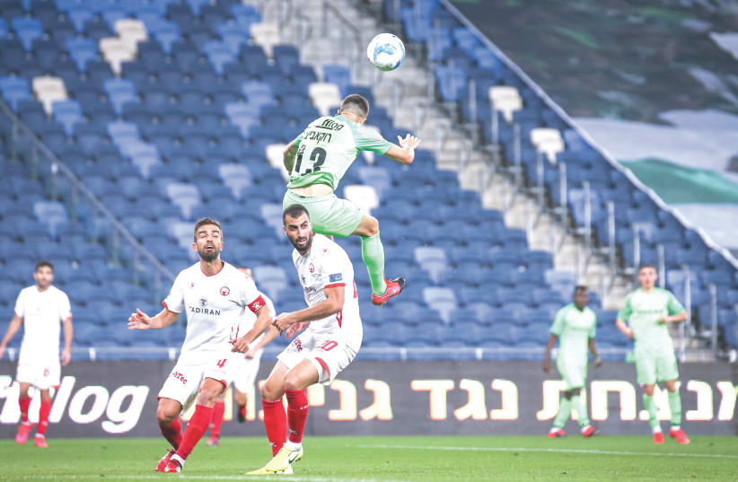 HAPOEL BEERSHEBA (in white) and Maccabi Haifa duel in the State Cup quartefinals in front of an empty Sammy Ofer Stadium stands – due to coronavirus concerns – in a match Beersheba claimed a 2-1 victory to advance. (photo credit: MAOR ELKASLASI)