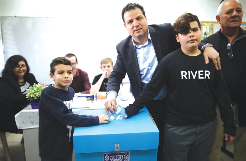 Joint List leader Ayman Odeh casts his ballot together with his sons in Haifa last week. (photo credit: AMMAR AWAD / REUTERS)