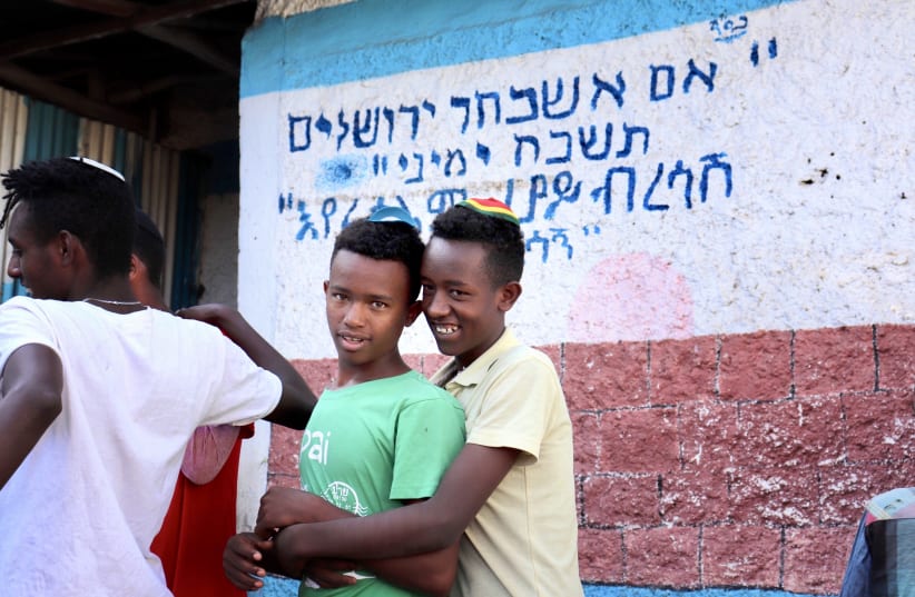 TWO BOYS before morning services at the Hatikva Synagogue in Gondar. In the back, the famous text reads: ‘If I forget you, O Jerusalem, may my right hand forget [its skill].’ (photo credit: CARMEL MADASHAHI)