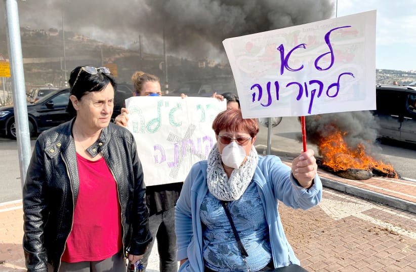 RESIDENTS HOLD placards (this one reads ‘No to corona’) as they demonstrate against a report that Israel may quarantine visitors from South Korea at a military base in Har Gilo, on February 23.  (photo credit: REUTERS)
