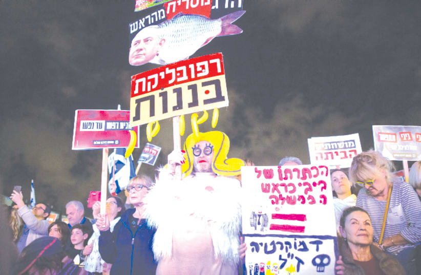 PROTESTERS AT HABIMA Square in Tel Aviv last November call on Netanyahu to quit, following the announcement by Attorney-General Avichai Mandelblit that the prime minister would stand trial. (photo credit: MIRIAM ALSTER/FLASH90)