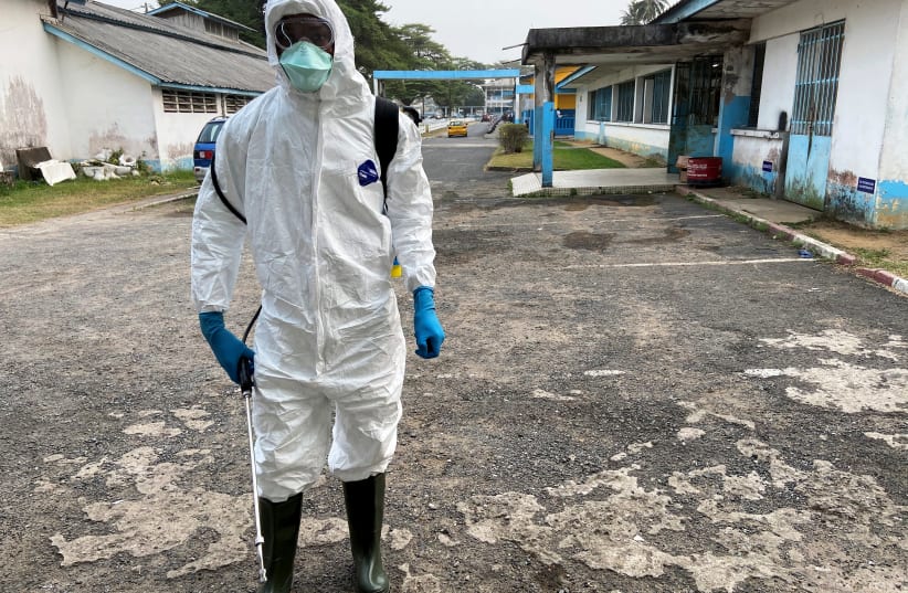 A medical staff wears protective gear at a new section specialised in receiving any person who may have been infected with coronavirus at The Quinquinie Hospital in Douala, Cameroon February 17, 2020 (photo credit: REUTERS/JOSIANE KOUAGHEU)