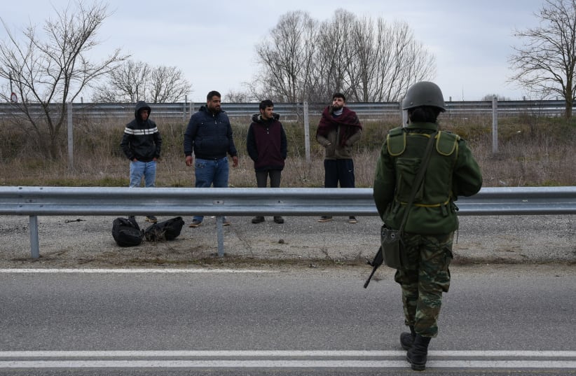 Syrian refugees that crossed the land borders between Greece and Turkey, are detained by Greek soldiers near the town of Soufli, Greece, March 4, 2020.  (photo credit: ALEXANDROS AVRAMIDIS/REUTERS)