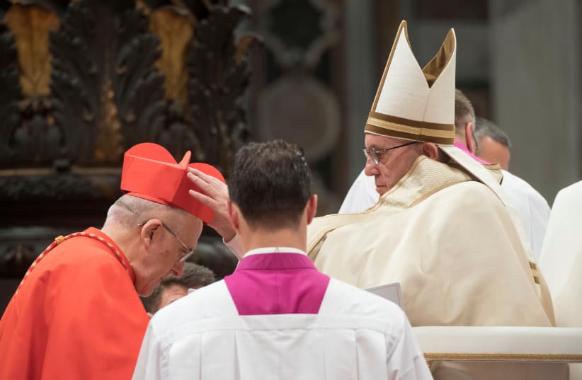 Pope Francis gives the traditional biretta hat to new cardinal Carlos Osoro Sierra of Spain during a consistory ceremony to install 17 new cardinals in Saint Peter's Basilica at the Vatican (photo credit: REUTERS)