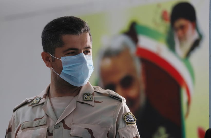 A member of Iranian Border Guards wears a protective face mask, following an outbreak of the new coronavirus, inside the Shalamcha Border Crossing, after Iraq shut a border crossing to travellers between Iraq and Iran, Iraq March 8, 2020 (photo credit: REUTERS/ESSAM AL-SUDANI)