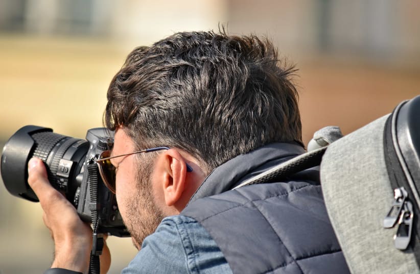 journalist photographer holding a camera (photo credit: PIXNIO)