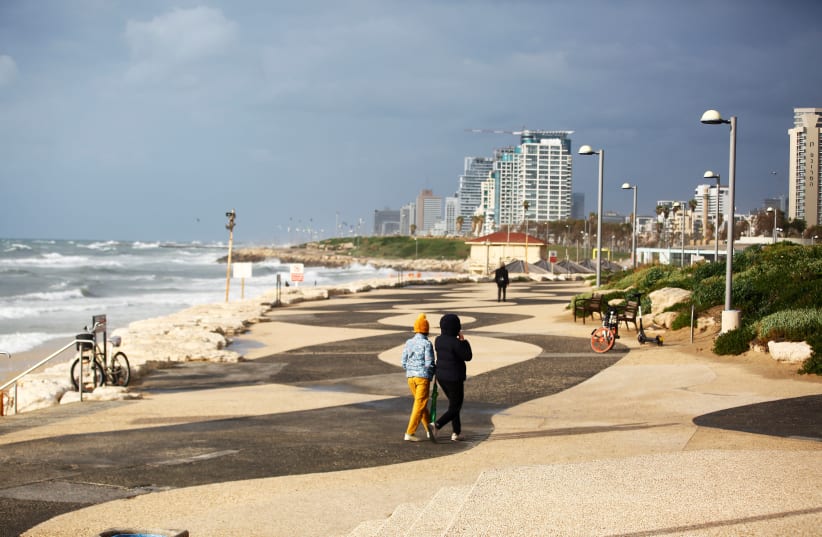 TWO PEOPLE walk near the beach in Tel Aviv (photo credit: REUTERS)