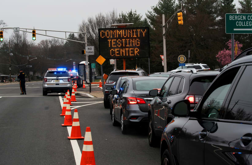People wait in their cars for being tested at a new drive-thru coronavirus disease (COVID-19) testing center at Bergen Community College in Paramus, New Jersey (photo credit: REUTERS)