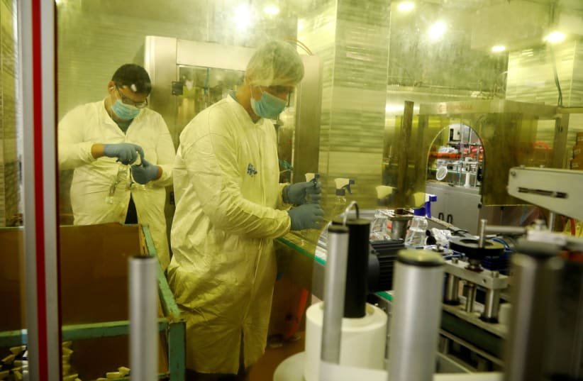 Palestinians work in a sanitizer factory amid precautions against coronavirus, in Jenin (photo credit: REUTERS)