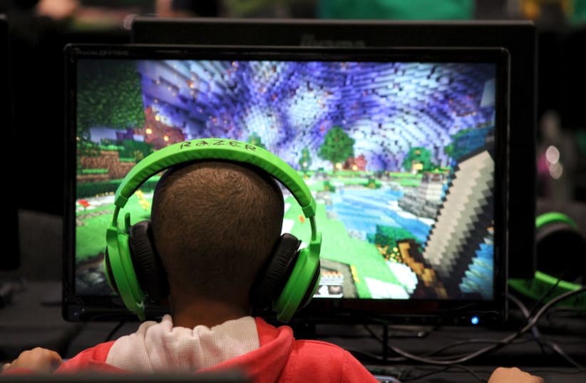 Child plays video game Minecraft at the Minecon convention in London (photo credit: REUTERS)