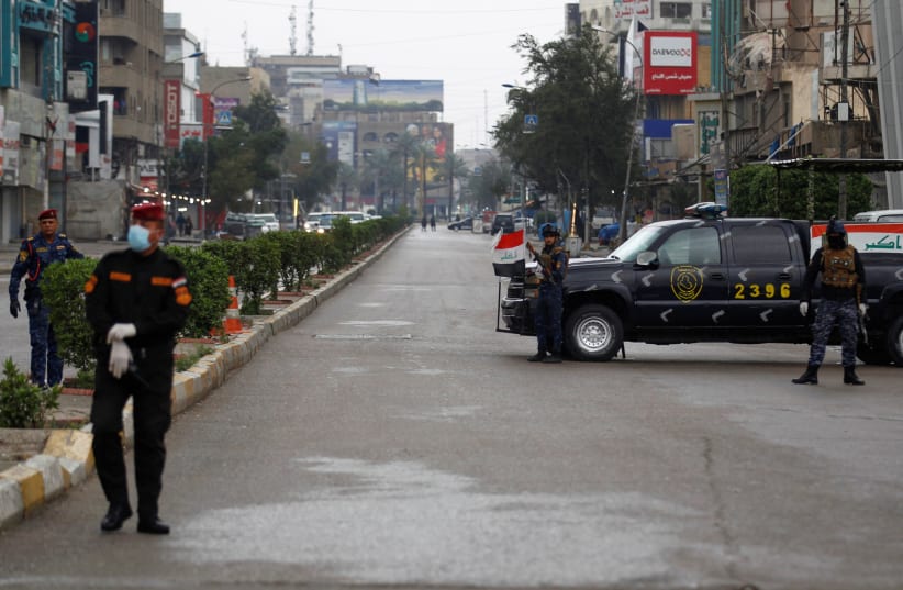 Iraqi security forces gather in a street, during a curfew imposed to prevent the spread of coronavirus disease (COVID-19), in Baghdad, Iraq (photo credit: REUTERS/KHALID AL MOUSILY)