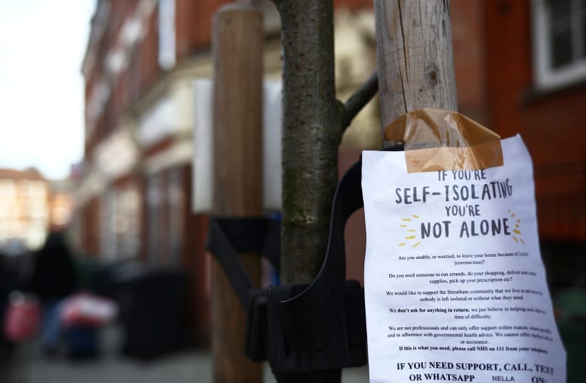 A sign is seen down a London street regarding self isolation as the spread of the coronavirus disease (COVID-19) continues. London, Britain March 21, 2020 (photo credit: HANNAH MCKAY/ REUTERS)