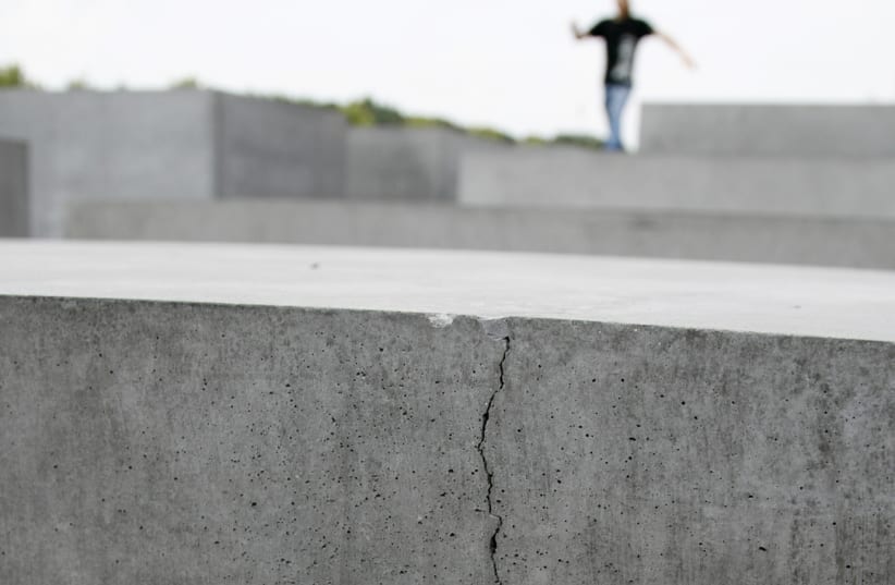A MAN stands atop the concrete blocks of the Holocaust-Mahnmal memorial, many of which have cracks. The book says German Holocaust memorials are insufficient (photo credit: REUTERS)