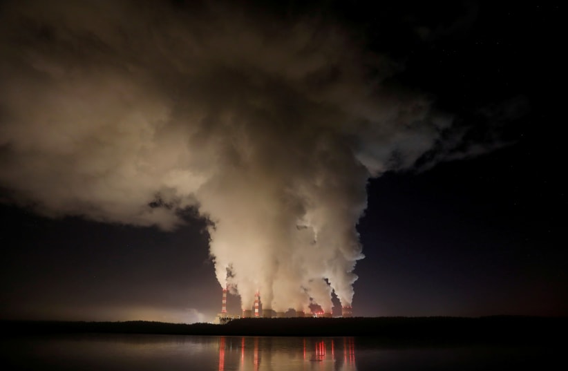 Smoke and steam billows from Belchatow Power Station, Europe's largest coal-fired power plant operated by PGE Group, at night near Belchatow, Poland December 5, 2018. (photo credit: REUTERS)
