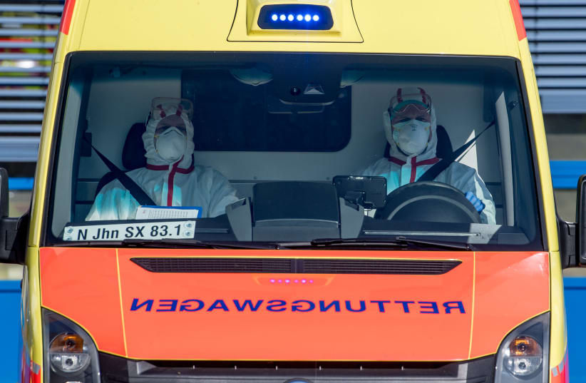 An ambulance car carries an Italian patient infected with coronavirus arrives at the Helios hospital in Leipzig, Germany, March 25, 2020, as the spread of the coronavirus disease (COVID-19) continues (photo credit: HENDRIK SCHMIDT/POOL VIA REUTERS)