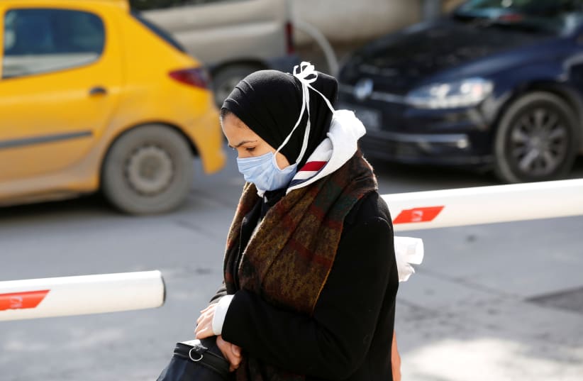 A woman wears a protective face mask as she walks in Tunis, Tunisia March 4, 2020 (photo credit: REUTERS/ZOUBEIR SOUISSI)